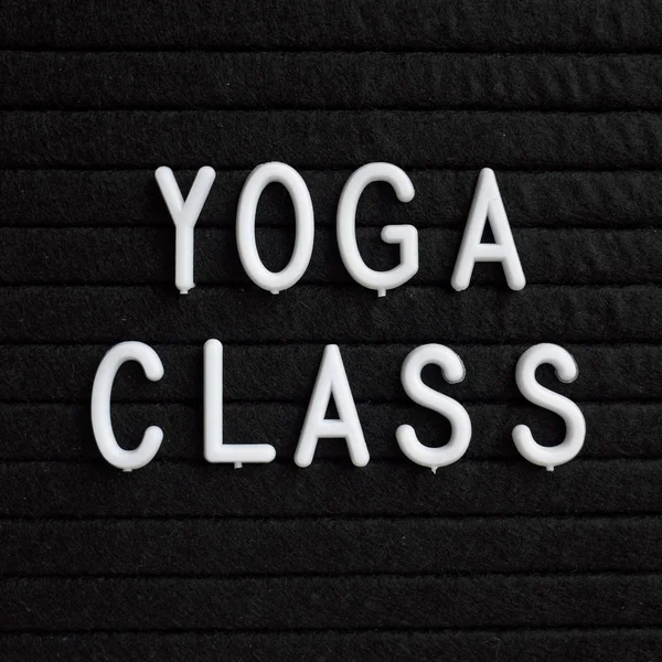 Fiziksel sağlık dikkat çekmek için bir hatırlatma olarak bir siyah harf tahtada beyaz plastik harflerle Yoga sınıf kelimeleri
