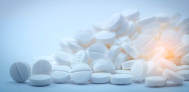 Pile of white tablets pill containing 
