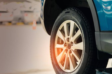 Seçici odak üstünde mavi Suv araba arka tekerlek üzerinde arka plan bulanık. Yüksek performans lastiği ile araba garaj Atölyesi'nde değişiklik lastik ve bakım sonra Park. Lastik seyahat kavramı önce kontrol.