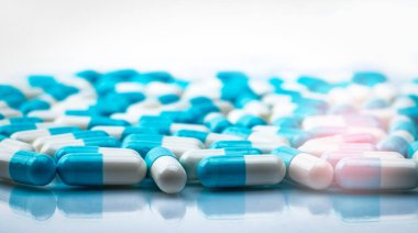 Gölge beyaz zemin üzerine mavi ve beyaz kapsül hap tarih seçici odak yayıldı. Küresel sağlık kavramı. Antibiyotik ilaç direnci. Antimikrobiyal kapsül hap. İlaç endüstrisi.