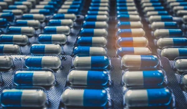 美しいパターンでアレンジ自在のブリスター パックに青と白のカプセル錠剤 グローバルなヘルスケアの概念 抗生物質耐性 抗菌カプセル錠剤 医薬品業界 — ストック写真