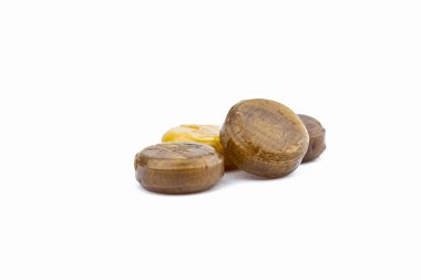 Yardım için tıbbi pastilleri öksürük, boğaz ağrısı ve beyaz arka plan üzerinde izole boğaz tahrişi. Çin bitkisel şeker. Kahverengi ve sarı pastilleri. Pastil. UME Erik ve mandalina limon şeker. 