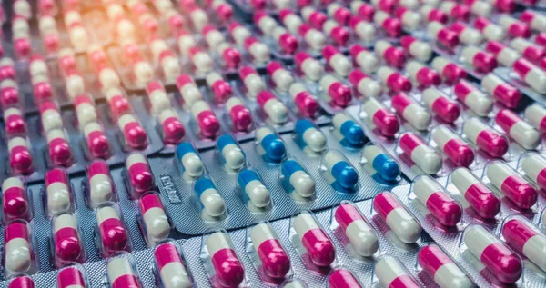 クローズ アップ ピンク白と青白色抗生物質は ブリスター パックの丸薬をカプセルします 抗菌薬剤耐性 製薬業界 グローバル ヘルスケア 薬局の背景 — ストック写真