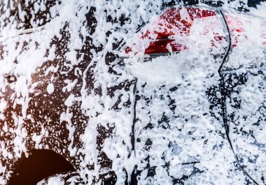 Arkadan Görünüş siyah kompakt Suv araba spor ve modern tasarımı ile beyaz köpük ve su ile yıkama. Araç bakım servisi iş. Araba beyaz köpükle kaplı. Oto Yıkama öncesi ve sonrası seyahat kavramı.