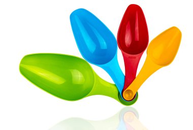 Renkli plastik kaşık gölge beyaz zemin üzerine izole ölçme kümesi. Yeşil, mavi, kırmızı ve turuncu plastik kaşık ölçme.