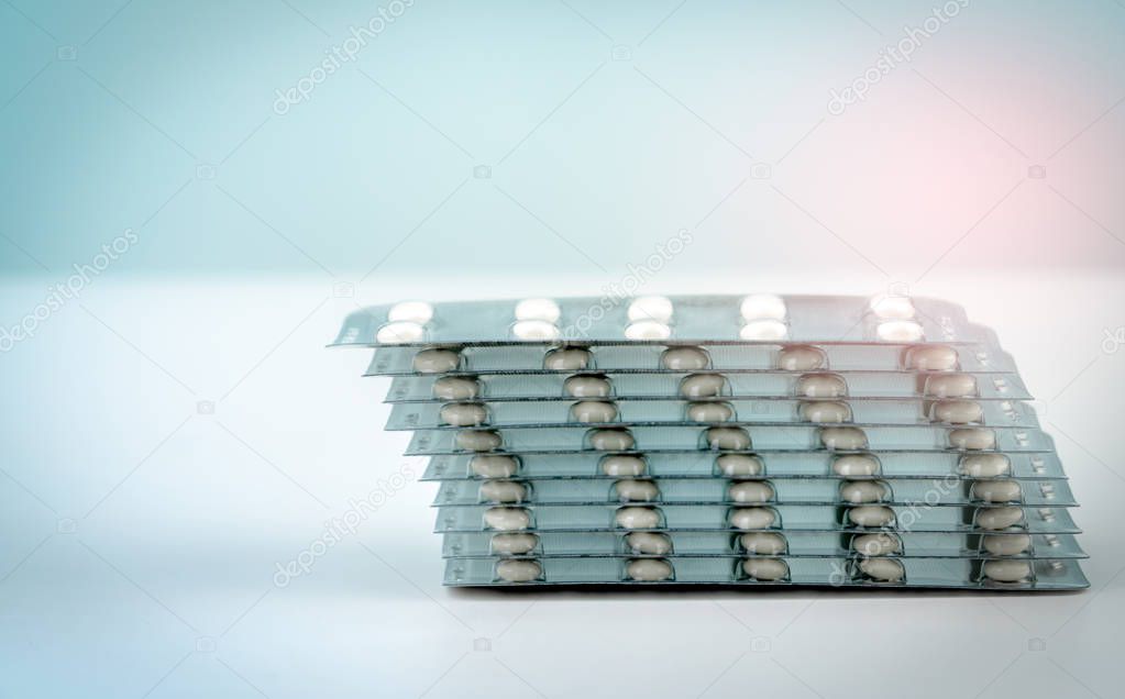 Stack of sugar coated tablet pill  on white background. Pharmacy background. Health budgets and policy. Pharmaceutical industry concept. Pharmaceutical packaging. White round drug. Healthcare concept 