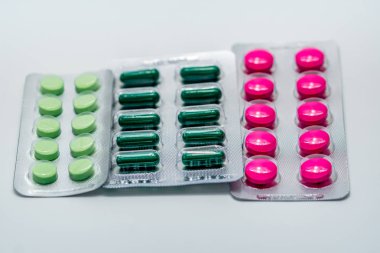 Pembe tabletler ve yeşil kapsül ve Vakumlu ambalaj beyaz zemin üzerine yeşil tablet. Ağrı kesici ilaç. İlaç endüstrisi. Eczane eczane arka plan. Eczane ürünleri. Küresel sağlık.