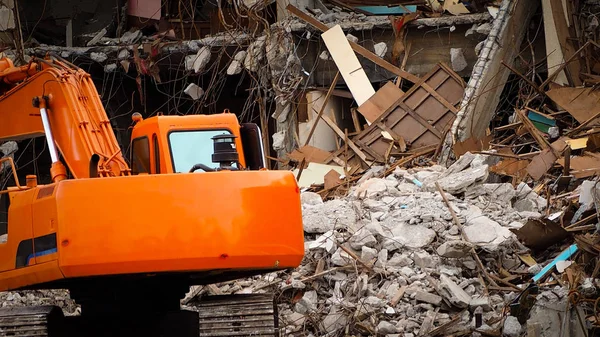 Destroyed building industrial. Building demolition by explosion. Abandoned concrete building with rubble and scrap. Earthquake ruin. Damaged or collapsed building from hurricane disaster. Backhoe.