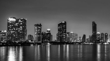 Cityscape akşam Nehri yakınında modern binanın. Modern mimari ofis binası. Gökdelen akşam gökyüzü ile. Siyah ve beyaz sesi resim. Gece fotoğrafçılığı riverfront Binası. 