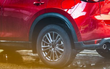 Kırmızı kompakt Suv araç spor tasarımı ile su ile yıkama. Araç bakım servisi iş kavramı. Otomatik su ve köpük sprey ile temizlendikten sonra su damlaları ile kaplı. Otomotiv Sanayi kavramı.