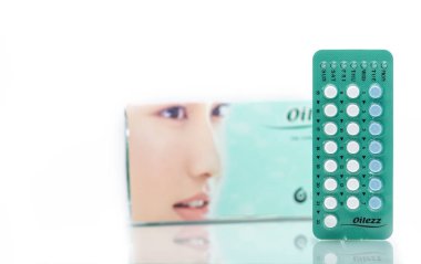 Chonburi, Tayland-Ekim 11, 2018: Oilezz. 22 hormonlar mavi ve beyaz tablet Vakumlu ambalaj üzerinde Doğum kontrol hapları kutusunun arka plan bulanık. Beyaz zemin üzerine oral kontraseptif hapları. Organon