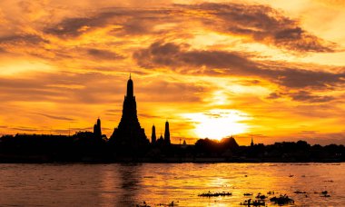 Nehir ve Wat Arun Ratchawararam batımında güzel turuncu gökyüzü ve bulutlar. Wat Arun Budist Tapınağı Bangkok, Tayland için dönüm noktası olduğunu. Siluet dramatik gökyüzü ve tapınak Tayland. 