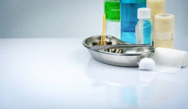 Yara bakım soyunma kümesi ve paslanmaz çelik plaka, forseps, alkol şişesi, tutarlı elastik bandaj, pamuk, kapsayıcı için cerrahi. Tıbbi malzeme. Beyaz arka plan üzerinde Tıbbi donatım araçları