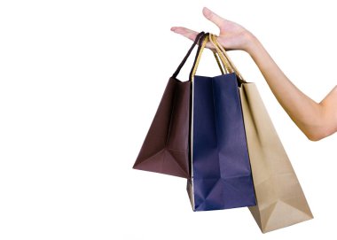 Kağıt alışveriş beyaz arka plan üzerinde izole çantaları taşırken bir kadın. Yetişkin kadın elini tut üç alışveriş çantası kahverengi ve mavi renk ile. Müşteri ve alışveriş çantası. Siyah Cuma kavramı. 