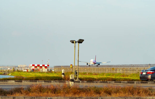 BANGKOK, THAILAND-DECEMBER 3, 2018 : Thai Smile Airways. Passenger plane is landing at Suvarnabhumi Airport in Thailand. Airbus A200. Fence and solar cell panels at the airport.