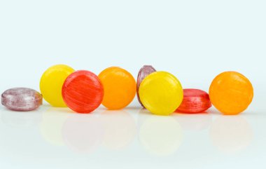 Yardım için tıbbi pastilleri öksürük, boğaz ağrısı ve beyaz arka plan üzerinde izole boğaz tahrişi. Öksürük ve soğuk algınlığı damla. Renkli öksürük pastil. Kırmızı, turuncu, sarı ve mor şeker veya şeker yuvarlak.