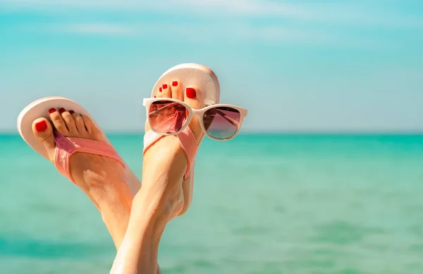 倒挂的女人脚和红色的脚脚穿着粉红色的凉鞋 太阳镜在海边 有趣和快乐的时尚年轻女子在假期放松 在海滩上冷静下来的女孩 创意为旅行社 周末旅游 — 图库照片