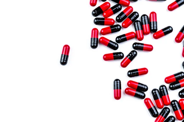 红黑胶囊丸传播在白色的背景 抗生素药物的使用与合理 制药行业 药学背景 全球医疗保健 成堆具有独特图案纹理的药丸 — 图库照片