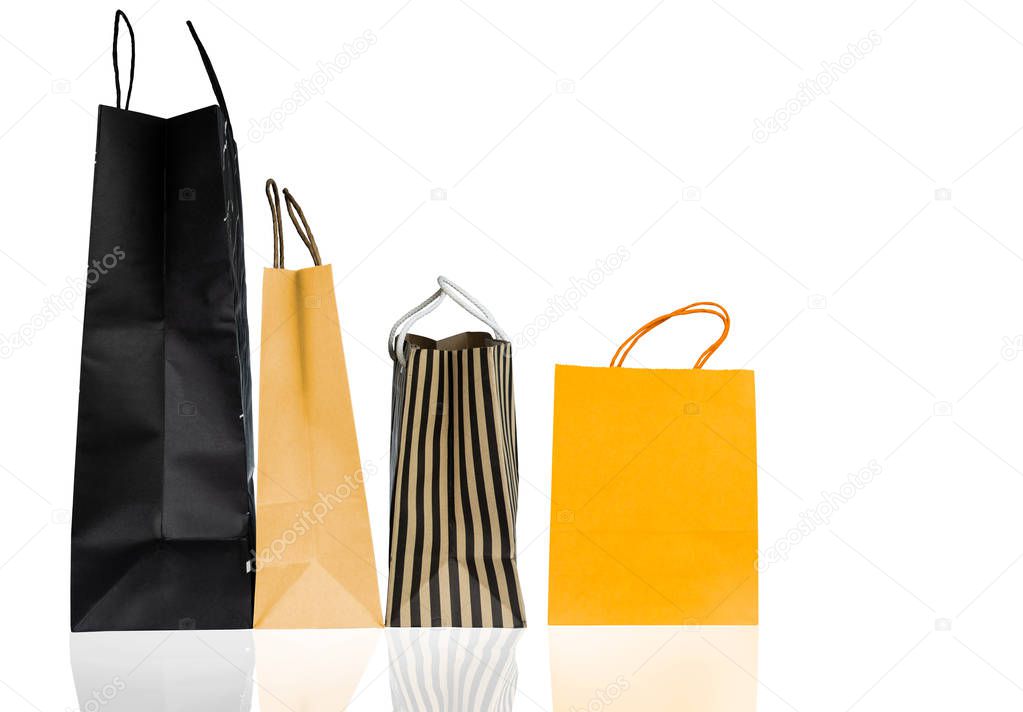 Four paper shopping bags isolated on white background. Shopping bag with blue, brown, and yellow color. Discount sales concept. Gift bag. Consumerism concept. Christmas or New Year present bag.