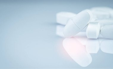 Hapları gri arka plan üzerinde beyaz dikdörtgen yığını tablet. İlaç endüstrisi. Eczane ürünleri. Ağrı kesici ilaç. Kalsiyum tabletleri. Antibiyotik tablet hap. Antibiyotik ilaç direnci kavramı.