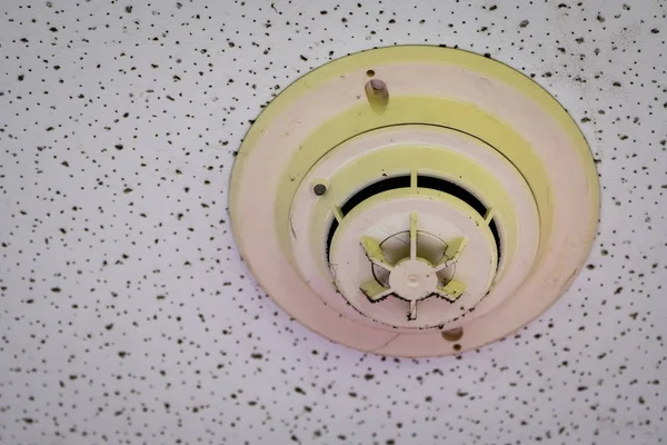 Old and dirty smoke detector with cobwebs on ceiling wall. Fire alarm system in house doesn\'t work. Emergency equipment in apartment need to clean and maintenance service. Carbon monoxide sensor.
