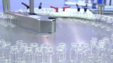 Dolum ve ambalaj için bekleyen rezerv paslanmaz çelik tepsisinde swirls şeffaf cam şişe grubudur. Arabellek veya yedek ilaç ürün hattı uzayda. İlaç fabrikası. 