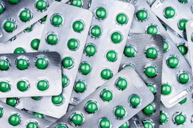 Closeup yığını yuvarlak yeşil şeker kaplı tablet hap Vakumlu Ambalaj içinde. Kabartma öksürük için hap birleştirin. İlaç ürün. İlaç endüstrisi. Eczane arka plan. Kuru öksürük için ilaç.