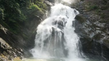 Ağır çekim Karome şelale Tayland. Şelale akan ve isabet büyük siyah taş düşüyor. Şelale granit Mountain tropikal orman içinde. Yemyeşil orman Asya. Güzel doğal konumlar.