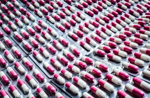 ピンク ホワイト ブリスター パックで抗生物質のカプセル錠剤。抗生物質耐性。医薬品包装業界。グローバル ・ ヘルスケア。薬局の背景。医薬品。生産ライン. — ストック写真