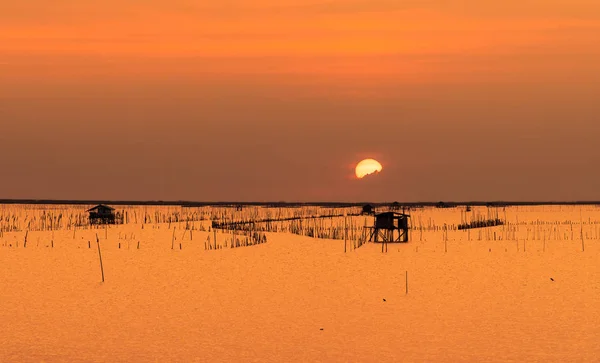 Прекрасное закатное небо над морем вечером. Солнце затемняется облаками на закате. Хижина рыбака прибрежного рыболовства в Таиланде. Море в сумерках. Силуэт мыса и хижины на берегу . — стоковое фото