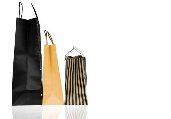 Τρεις χαρτί τσάντες αγορών που απομονώνονται σε λευκό φόντο. Τσάντα για ψώνια με μαύρο, καφέ και κίτρινο χρώμα. Έκπτωση πωλήσεων έννοια. Δώρο τσάντα. Έννοια του καταναλωτισμού. Χριστούγεννα ή Πρωτοχρονιά παρόντες τσάντα. — Φωτογραφία Αρχείου