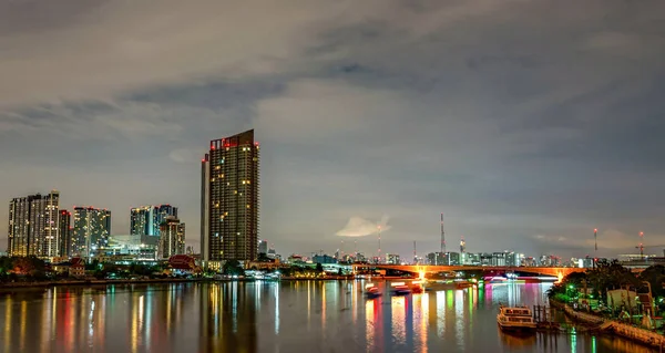 Cityscape do edifício moderno perto do rio na noite. Edifício de escritórios de arquitetura moderna. Arranha-céu com céu noturno. Imagem de tom preto e branco. Fotografia noturna do edifício ribeirinha . — Fotografia de Stock