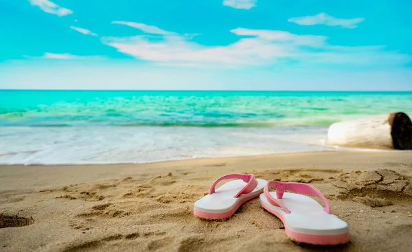 Rosa och vita sandaler på sandstrand. Avslappnad stil flip-flop var bort på seaside. Sommarlov på tropical beach. Kul semesterresor på sandstrand. Sommartid. Sommar vibbar. Avkopplande stund. — Stockfoto