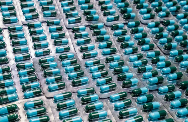 Pillole di capsula antibiotica verde-blu di primo piano in blister. Resistenza antimicrobica al farmaco. Industria farmaceutica. Sanità globale. Esperienza in farmacia. Prodotto farmaceutico. Capsula di amoxicillina — Foto Stock