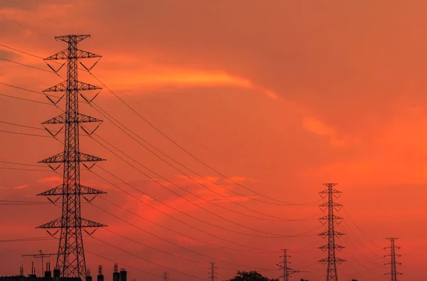 High voltage electric pole and transmission lines in the evening. Electricity pylons at sunset. Power and energy. Energy conservation. High voltage grid tower with wire cable at distribution station.