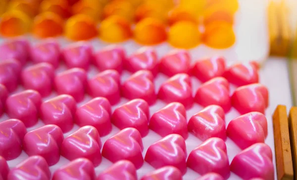 Pink heart shape chocolate. Valentine's day gift. White chocolate ganache with rose scent on white plate. Chocolate pralines. Luxury chocolate candy. Delicious dessert. Food for love and dating. — Stock Photo, Image