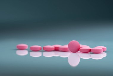 Gradyan arka planda yuvarlak pembe tablet hap. Vitamin ve mineraller artı folik asit E vitamini ve çinko degrade arka plan üzerinde ilaç şişesi. Hamilelik sırasında ve sonrası kadın için pembe tablet hapları.