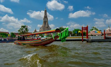 Bangkok, Tayland-Mart 8, 2019 : Yabancı turistler güzel mavi gökyüzü ve beyaz bulutlar ile güneşli bir günde Chao Phraya nehri boyunca Wat Arun Ratchawararam izlemek için tekne kiralamak. Budist tapınağı. 