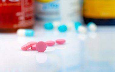 Yuvarlak pembe tablet hap ilaç şişe arka plan bulanık. Ağrı kesici ilaç. Uyuşturucu tedavi migren baş ağrısı için kullanın. Eczane ürünleri. İlaç endüstrisi. Uyuşturucu kullanımı günlük yaşamda.