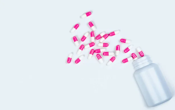 Ροζ-Λευκό καψάκιο χάπια εξαπλωθεί έξω από το μπουκάλι των ναρκωτικών. Αντιψυχωτικό φάρμακο. Κάψουλες φάρμακο για την κατάθλιψη θεραπεία. Αντι-άγχος ναρκωτικών. Καθολική υγειονομική περίθαλψη. Φαρμακείο φόντο. Φαρμακευτική βιομηχανία. — Φωτογραφία Αρχείου