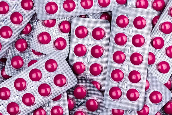 Pile of round pink tablets pill in blister pack. Pharmaceutical industry. Pharmacy products. Prescription drug. Painkiller medicine. Ibuprofen for treatment headache, high fever, migraine. NSAIDs drug — Stock Photo, Image