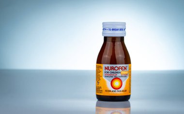 Chonburi, Tayland-Ekim 27, 2018: Nurofen degrade arka plan üzerinde kehribar şişe. Çocuklar için ibuprofen oral süspansiyon. Tedavi ateş ve çocuklarda ağrısı için ilaç. Alkol ücretsiz ilaç.