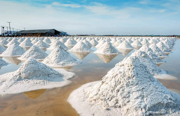 Granja de sal marina y granero en Tailandia. Sal marina orgánica. Materia prima de sal industrial. Cloruro de sodio. Sistema de evaporación solar. Fuente de yodo. Trabajador trabajando en la granja en un día soleado con cielo azul . — Foto de Stock