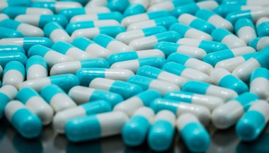 Mavi ve beyaz antibiyotik kapsül hapları seçici odak. İlaç endüstrisi. Antibiyotik ilaç direnci kavramı. Eczacılık kavramı. Pastel kapsül hapları. Eczane eczane arka plan.