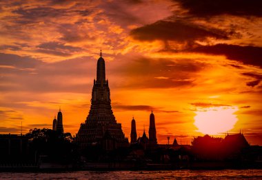 Wat Arun Ratchawararam batımında güzel kırmızı ve turuncu gökyüzü ve bulutlar. Wat Arun Budist Tapınağı Bangkok, Tayland için dönüm noktası olduğunu. Cazibe sanat. Siluet dramatik gökyüzü ve Tapınak. 