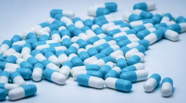Beyaz arka planda mavi ve beyaz kapsül hapları. Antibiyotikler ilaç direnci. Antimikrobiyal kapsül hapları. İlaç endüstrisi. Sağlık ve eczane. Eczacılık kavramı. Hastanede ilaç. 