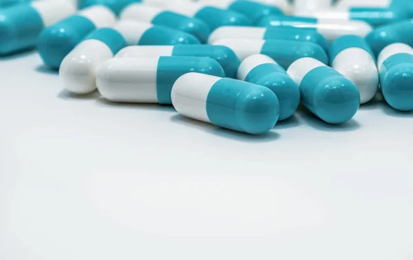 Kék és fehér kapszula pirulák fehér alapon. Antibiotikumok gyógyszerekkel szembeni rezisztencia. Antimikrobiális kapszula tabletták. Gyógyszeripar. Egészségügy és drogáruház. Gyógyszerészet fogalma. Kábítószer-kórházban. — Stock Fotó