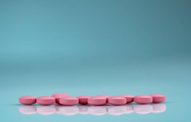 Gradyan arka planda yuvarlak pembe tablet hap. Vitamin ve mineraller artı folik asit E vitamini ve çinko degrade arka plan üzerinde ilaç şişesi. Hamilelik sırasında ve sonrası kadın için pembe tablet hapları.