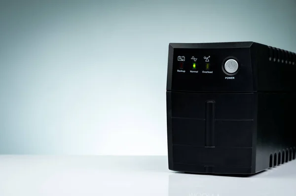 Uninterruptible power supply. Backup Power UPS with battery isolated on table. UPS for PC. Equipment for computer system at office for security. Power protection solutions from home to data center. — Stock Photo, Image