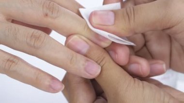 Manikürcüde kadın güzellik uzmanından oje alıyor. Manikürcü tırnak cilası temizleyici kullanıyor. Tırnak rengi aseton ürünüyle alınmış. Tırnak temizleme işlemi.